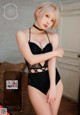 A woman in a black lingerie posing for the camera.