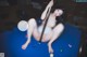 A woman sitting on top of a pool table holding a cue.